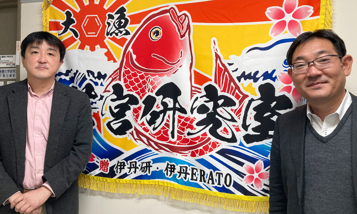 In front of the big fish flag given to him by a senior colleague, who wished him "a big catch for the results of his research."